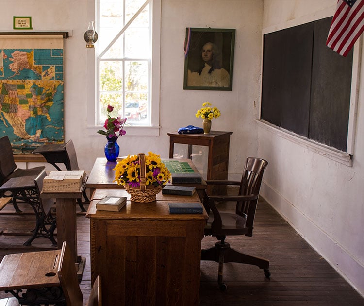 Empty teacher's desk in a classroom.