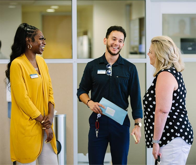 Three diverse employees smiling and talking