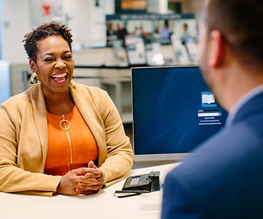 African American woman smiling across a desk from a man in a suit