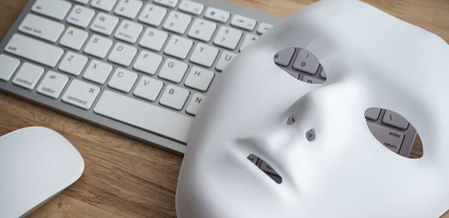 Mask rests atop of keyboard and mouse.